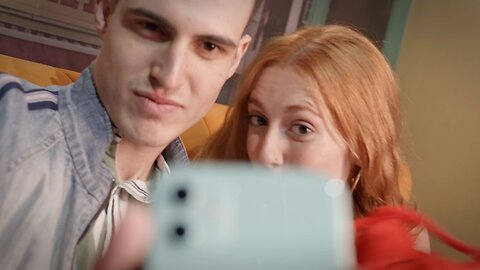 Lovely couple makes a funny video with lobster plushie in front of a smartphone