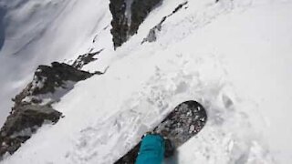 Snowboarder films downhill descent on slope