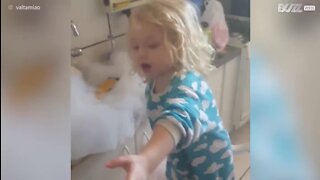 Cette fillette "aide" sa mère à faire la vaisselle