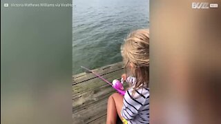 Une fillette ravie d'avoir pêché son premier poisson