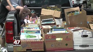 Volunteers pass out books to kids during Memorial Day parade