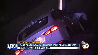 Cars crash into fallen light pole; driver arrested