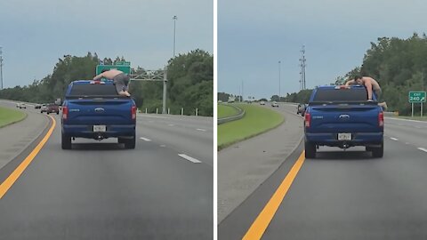 Man climbs out of truck on highway to grab beer from the back