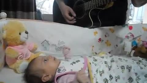 Baby girl captivated by her dad's guitar playing