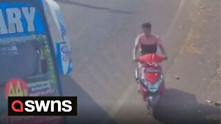 Man onboard scooter narrowly misses bus as it speeds around the corner in India