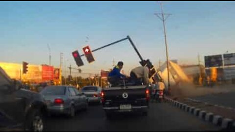 A truck slides across street and crashes into traffic light