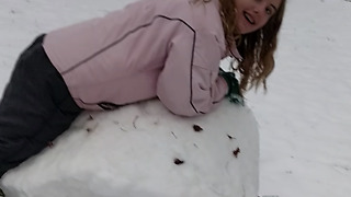 A Girl Rolls Snow Like It's Hay