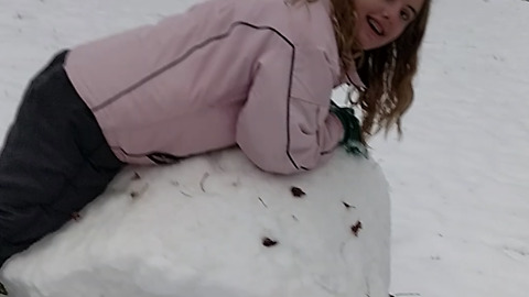 A Girl Rolls Snow Like It's Hay