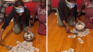 Family plays hilarious blindfold money-scooping game