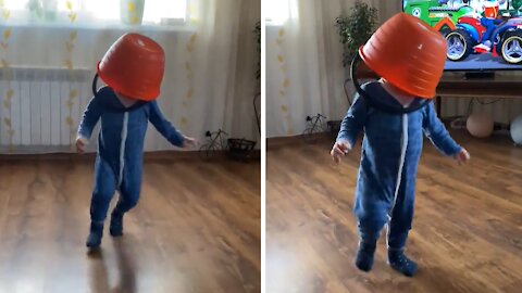 Little Kid Humorously Runs Around Room With Bucket On His Head