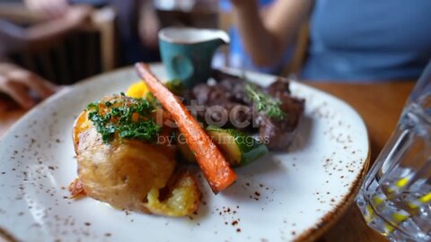 Gourmet food on plate at restaurant with people in