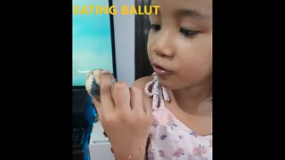 Girl eats balut