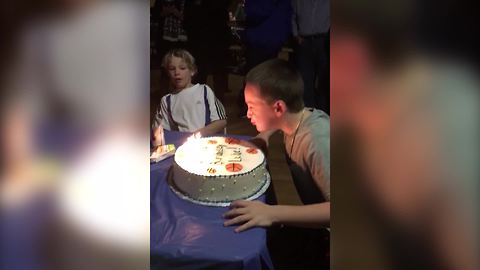 Three Kids Try To Blow Out The Candles On A Birthday Cake