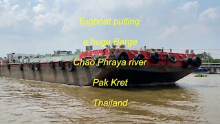 Tugboat pulling a Huge Barge at Chao Phraya river in Thailand