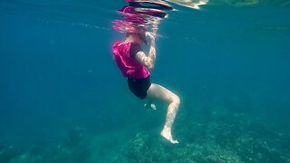 Lady in pink swimming in the ocean