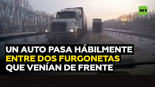 Un auto pasa entre dos camiones lanzados de frente en una autopista helada