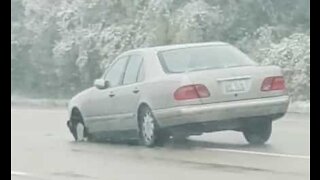 Il conduit sans pneu avant sous la pluie