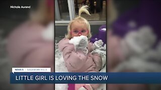 Adorable girl loves eating snow