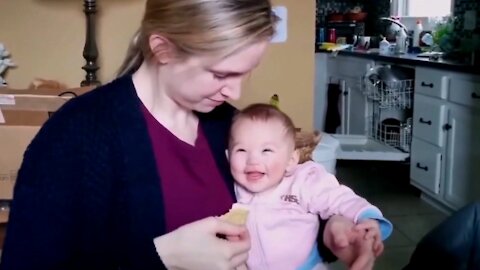 Funny baby laughs when her mother eats