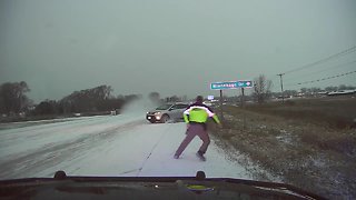 Oncoming motorist slides out of control and nearly strikes a police officer