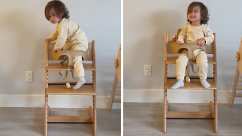 Fearless toddler climbs into high chair on his own
