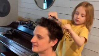 Filha corta o cabelo ao seu pai