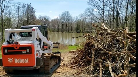 Bobcat T650 Root grapple skid steer clearing firewood and brush Illinois