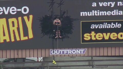 SteveO hanging from billboard in LosAngeles for steveo.com