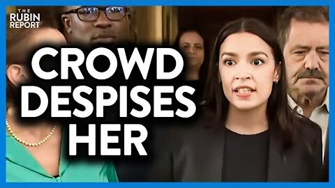 WATCH AOC STRUGGLE TO KEEP SMILING AS CROWD SCREAMS AT HER