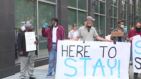 Homeless men staying at hotel gather outside county HQ