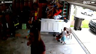 Bebê pega carona em portão de garagem