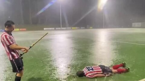 Soccer player pretends to be a fish during heavy rainstorm
