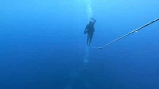 Diver walks tightrope under water