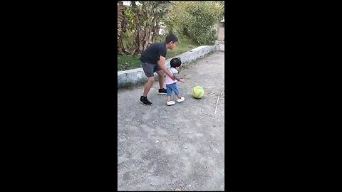 baby girl playing football with her brother