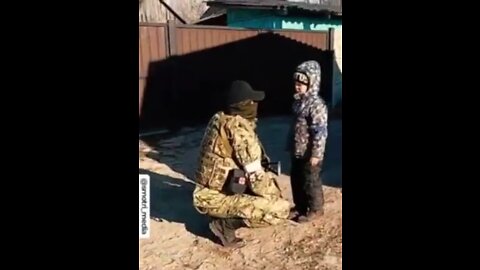 Hungry little boy is given rations by Chechen soldiers