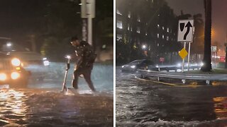 Brave man with scooter walks through extreme flood