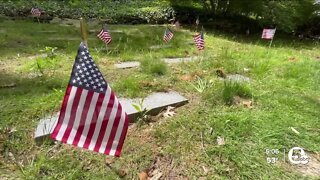 Volunteers begin the process of placing close to 9,000 flags on veterans' graves