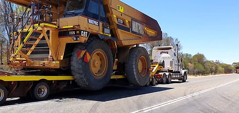Scania and International with lowboy low loaders hauling CAT 777D off highway mining trucks