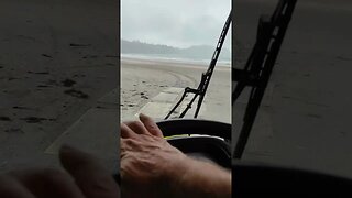 Truck driving on the beach.