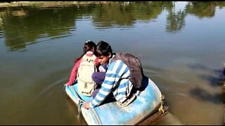 Villagers use plastic barrels to cross a river in India