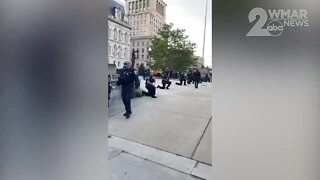 Baltimore Police officers kneel in solidarity with protesters