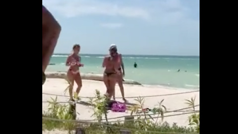Man recording women on the beach