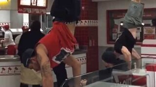 Fitness boys do handstand in middle of fast food restaurant