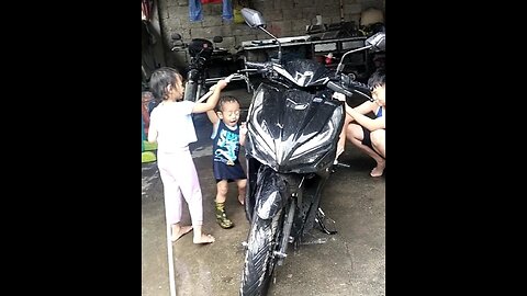 Funny siblings washing motorcycle