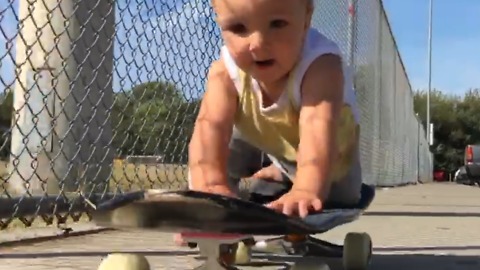 A Baby Boy Rides a Skateboard Outdoors