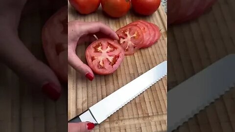 Cutting a tomato with a serrated knife