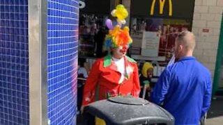 Man and clown have heated discussion in middle of street