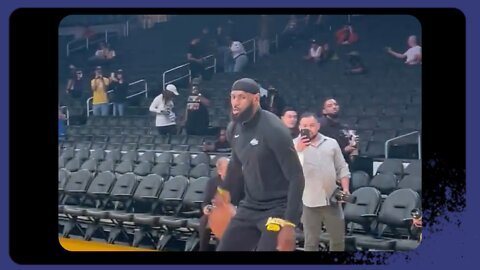 LeBron is getting shots up on the court with a Phil Handy before the game