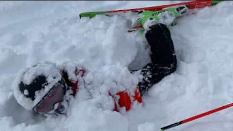 Guy buried head-first in snow after failed ski jump
