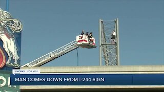 Negotiators talk man down from I-244 sign